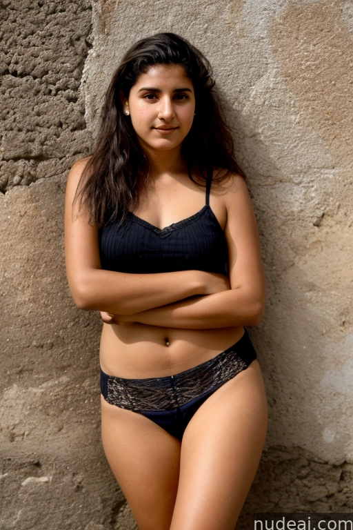 arafed woman in a black bikini and panties leaning against a stone wall