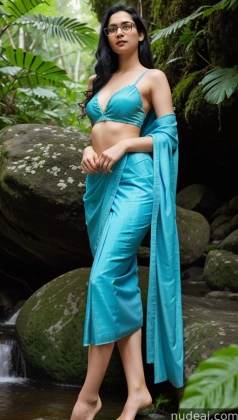 a pregnant woman in a blue sari standing in a stream