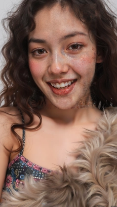 arafed girl with freckles and a furry coat smiling