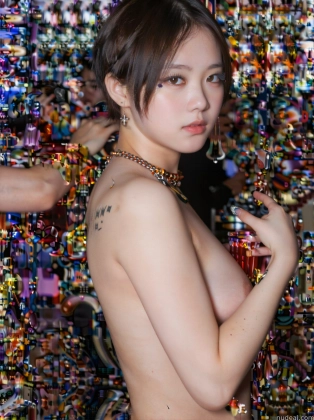 there is a woman that is posing in front of a wall of beads